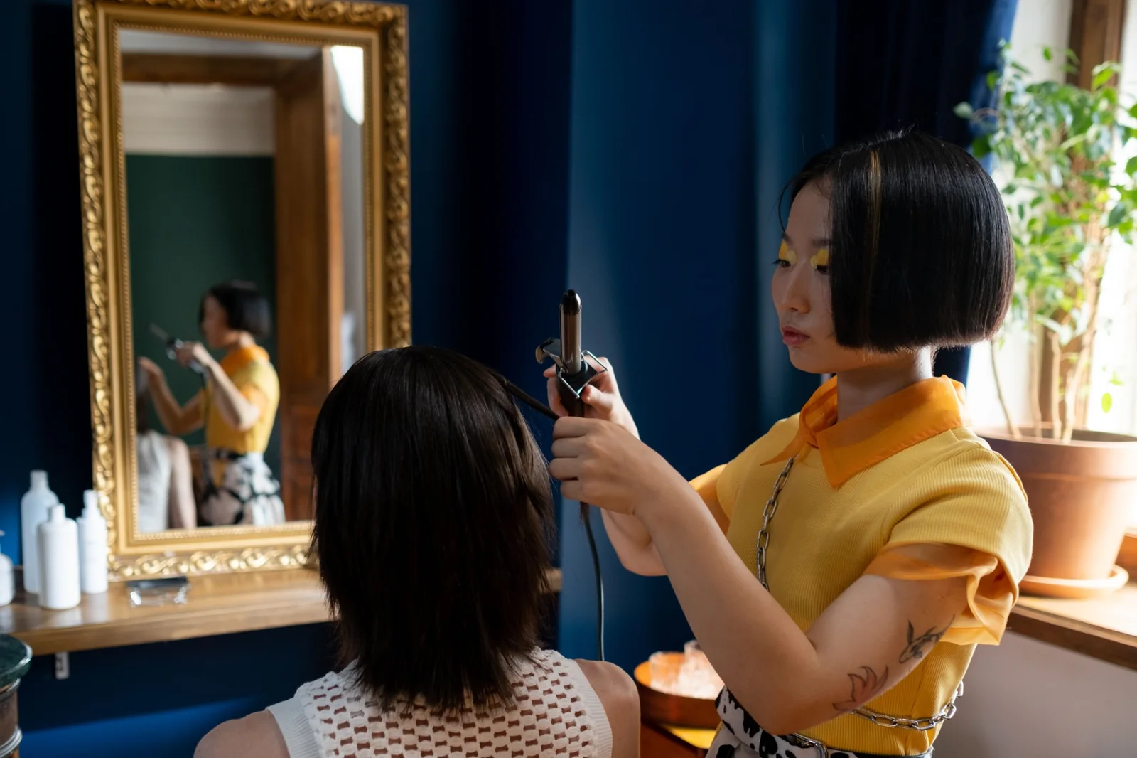 Hair stylist curling a client's hair in a salon