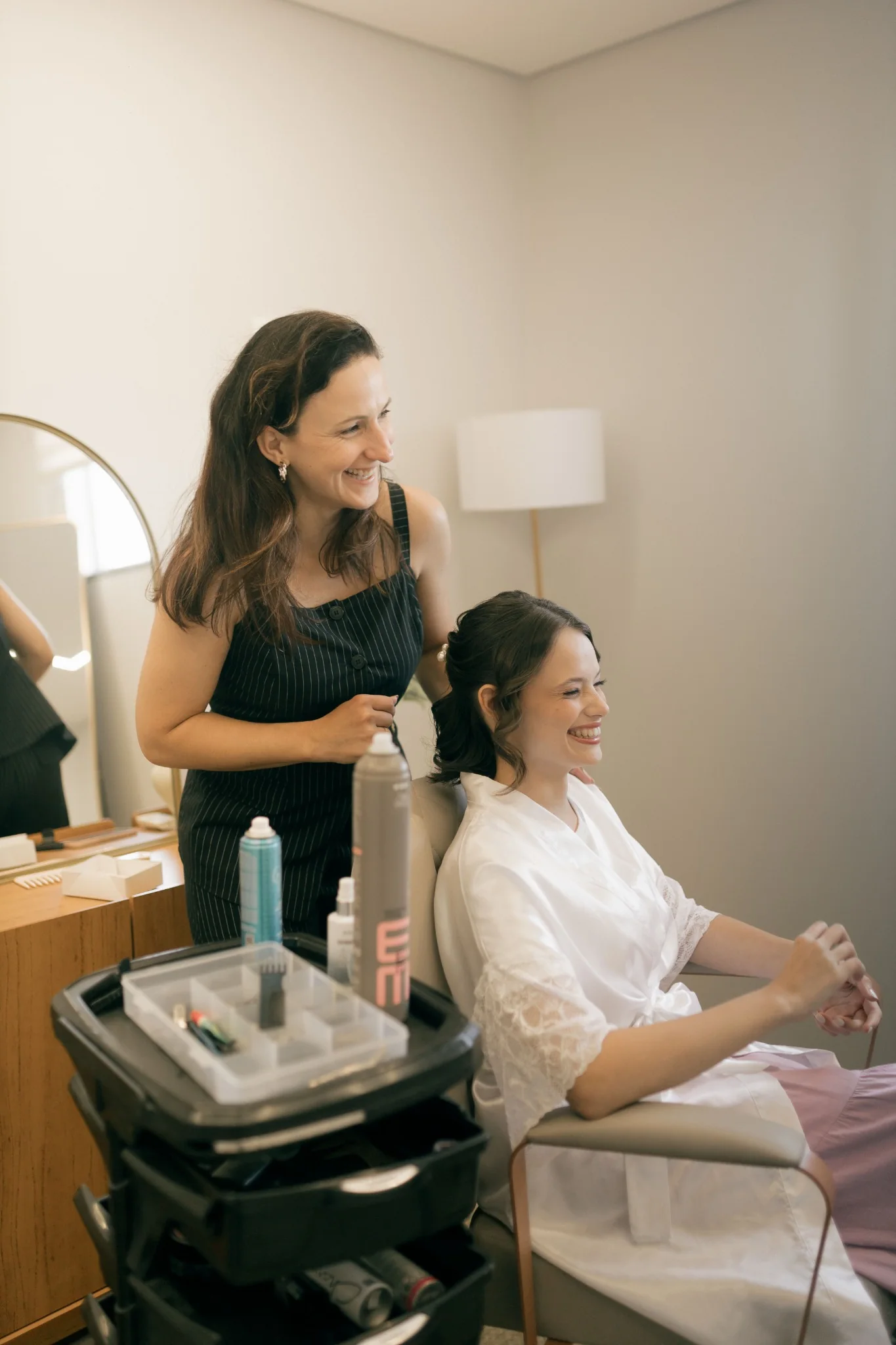 Hair stylist with a smiling seated client