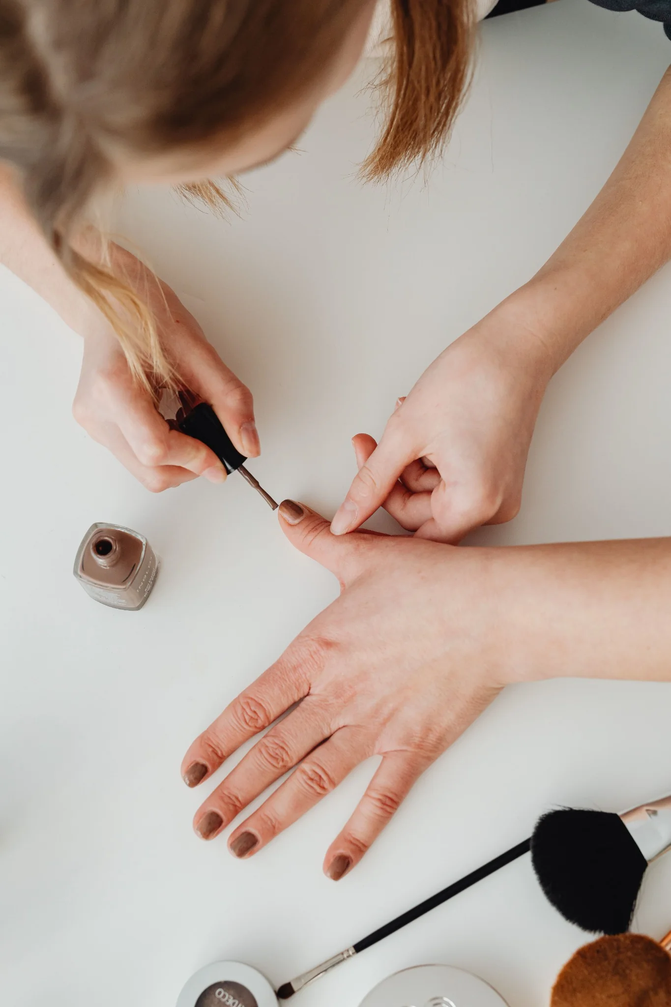 Nail professional applying polish during a manicure