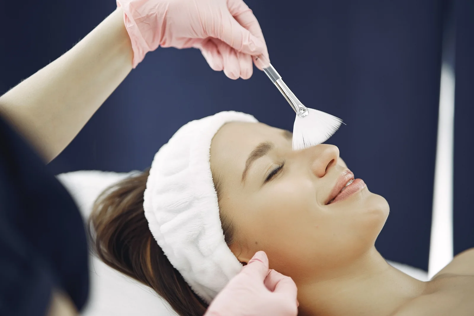 Esthetician applying a facial treatment to a client