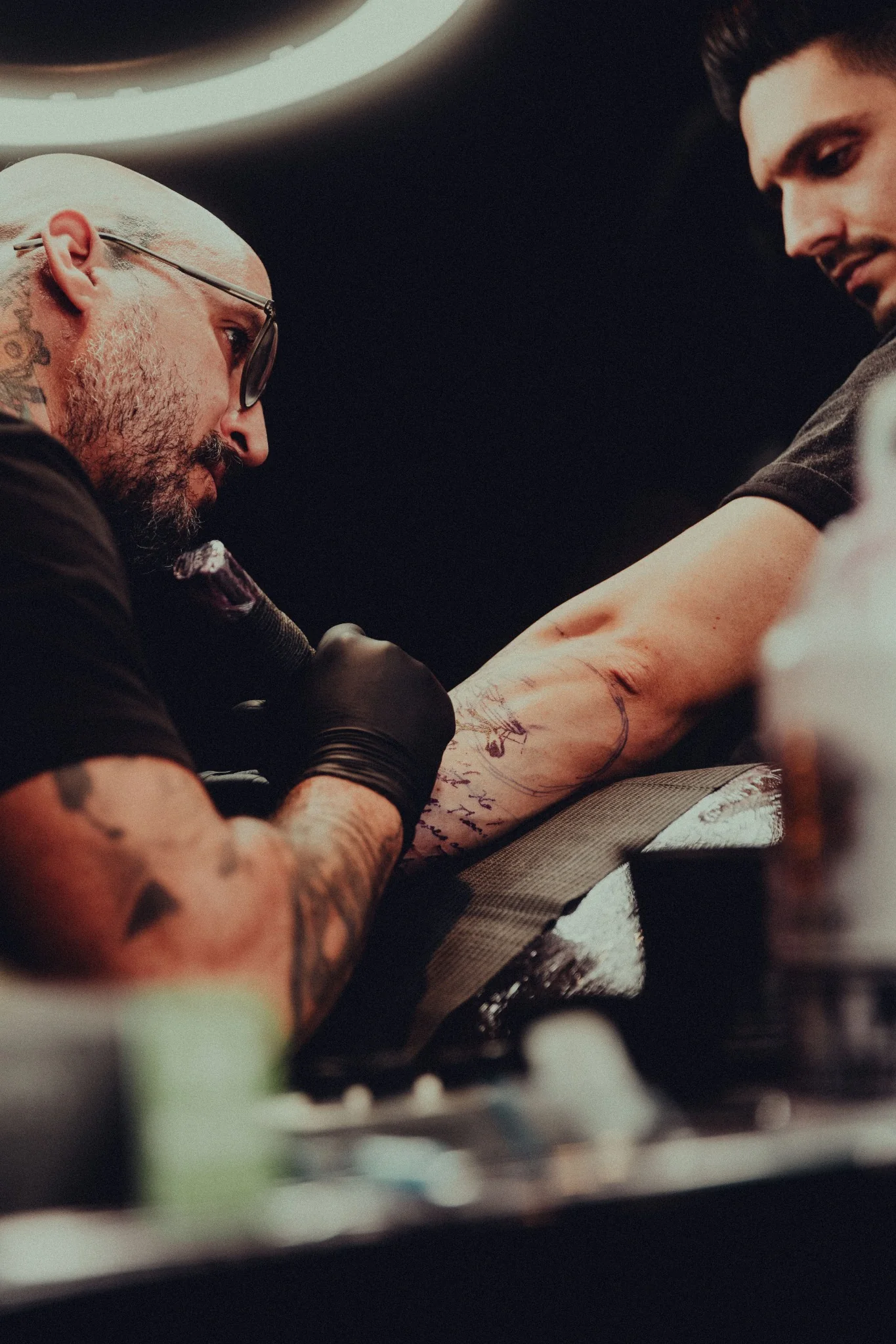 Tattoo artist working on a client's arm